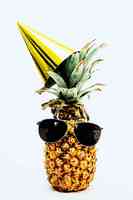菠萝戴黑色飞行员式太阳镜和派对帽图片素材